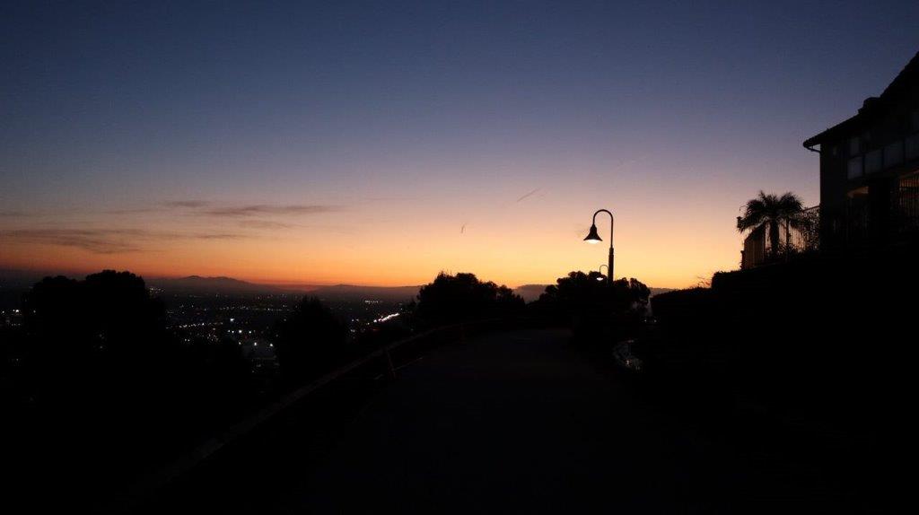 A street light and a city at sunset

Description automatically generated