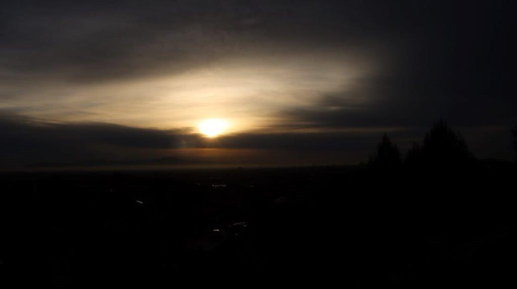 A sun setting over a city

Description automatically generated
