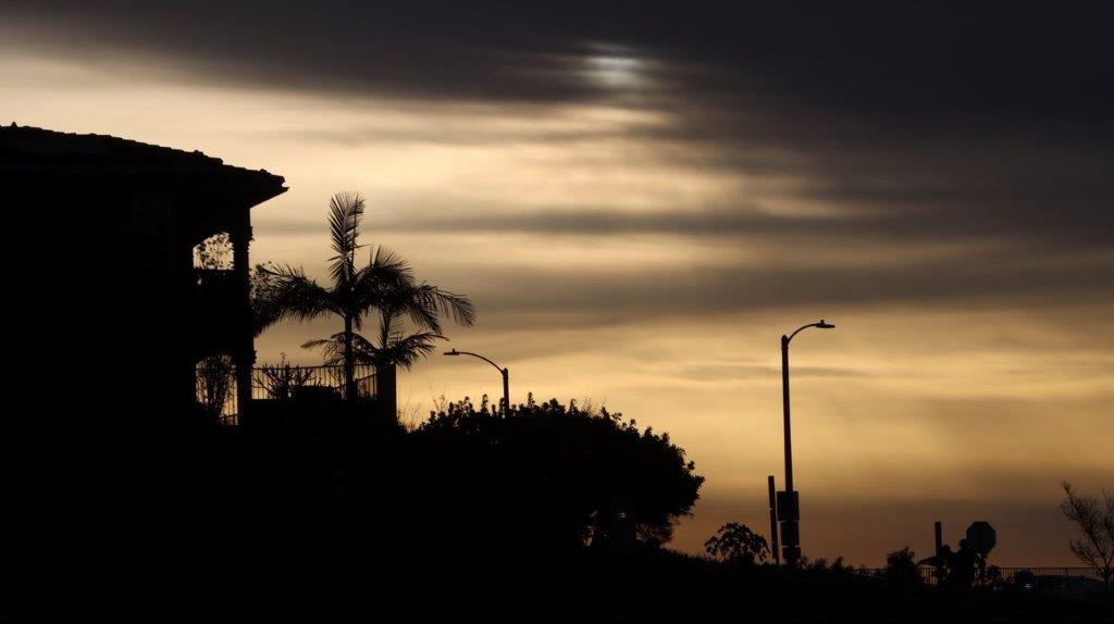 A silhouette of a building and a street light

Description automatically generated