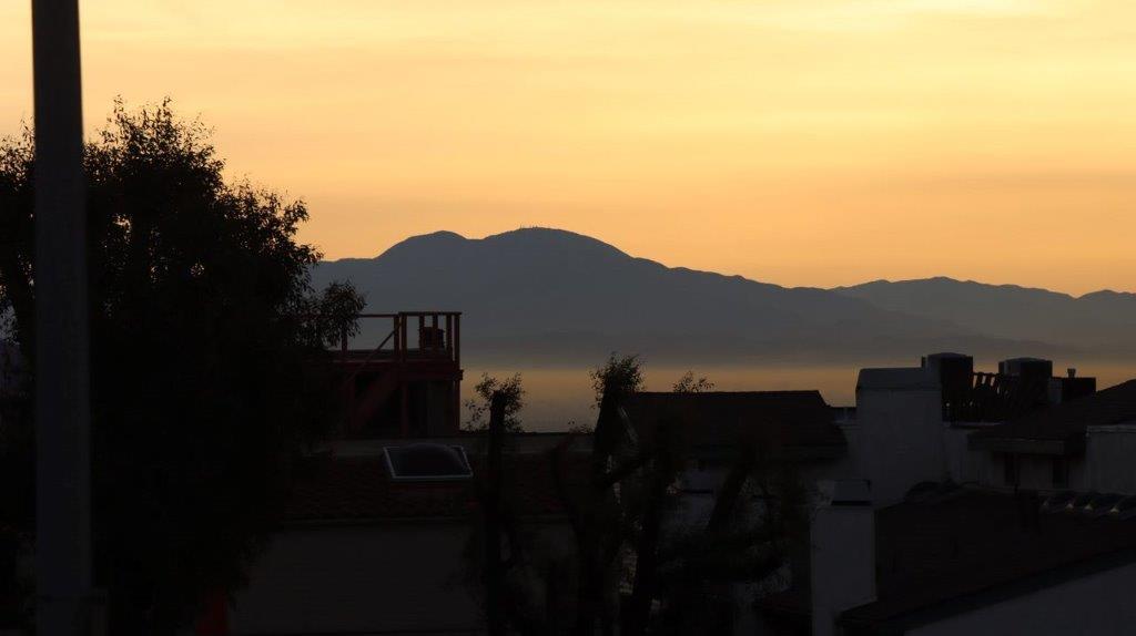 A silhouette of a building and mountains in the distance

Description automatically generated