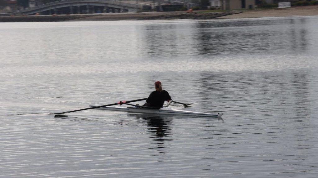A person rowing a boat on the water

Description automatically generated