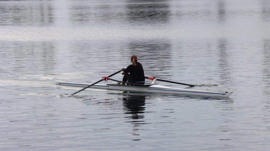 A person rowing a boat on the water

Description automatically generated