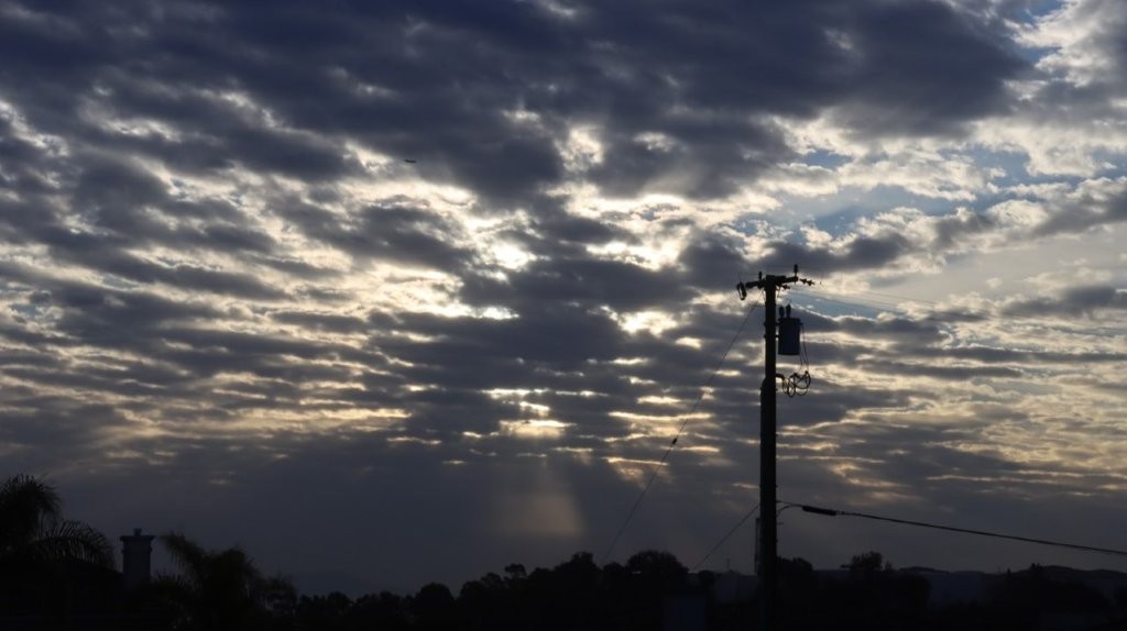 A telephone pole with clouds in the sky

AI-generated content may be incorrect.
