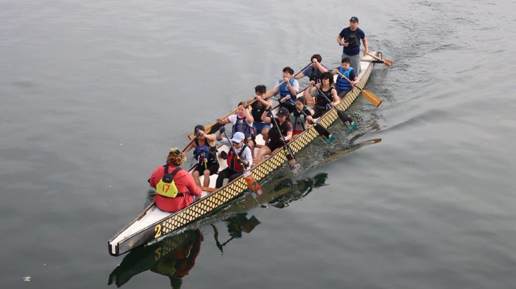 A group of people rowing a boat

Description automatically generated