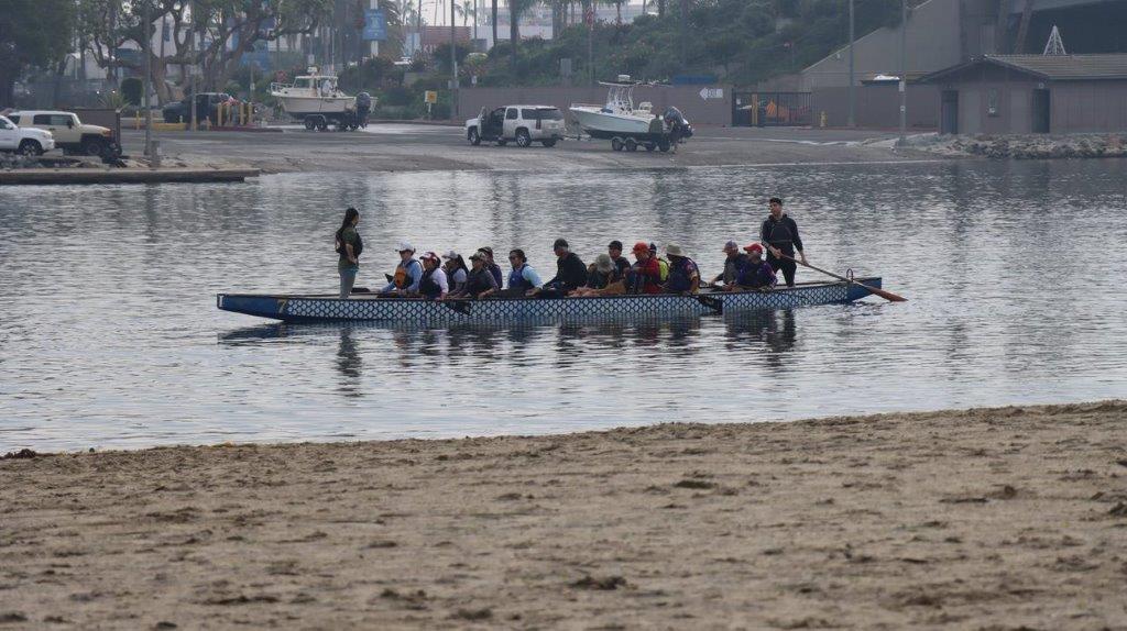 A group of people rowing a boat

Description automatically generated