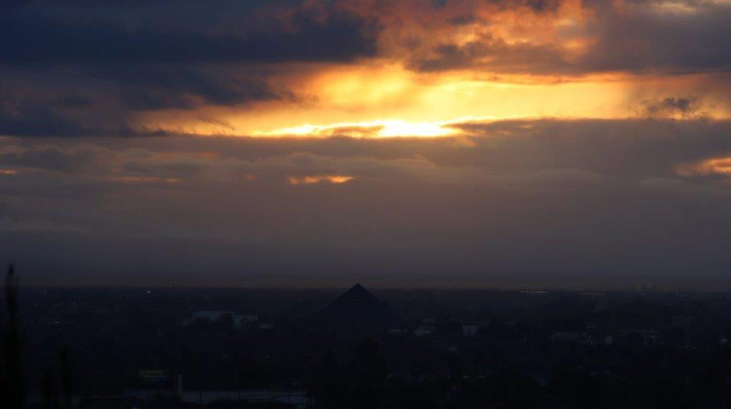 A sun setting behind clouds

Description automatically generated