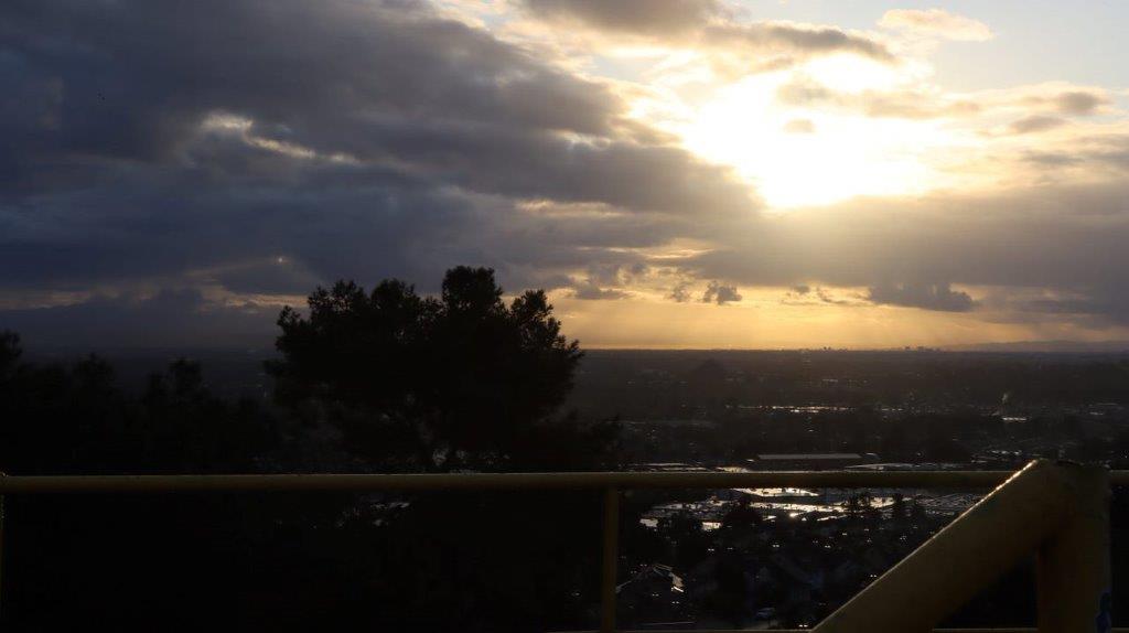 A sun setting over a city

Description automatically generated