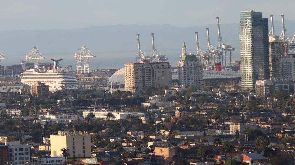 A city with cranes in the background

Description automatically generated