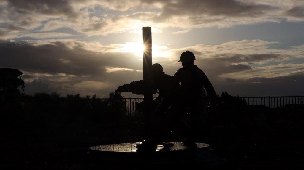 Silhouette of people working on a pole

Description automatically generated