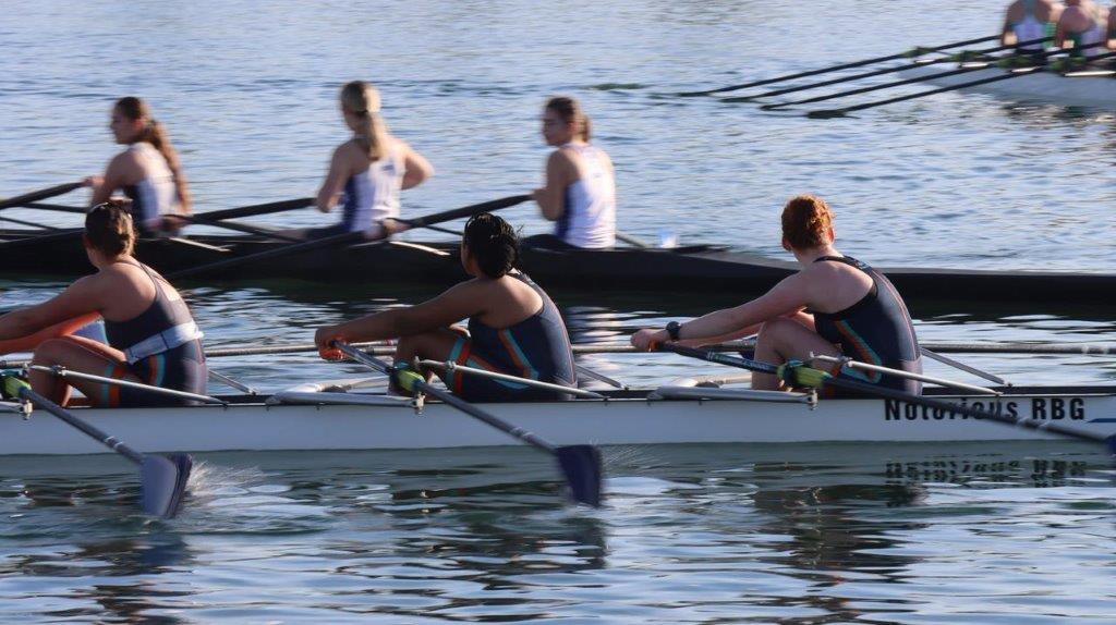 A group of women rowing on the water

Description automatically generated