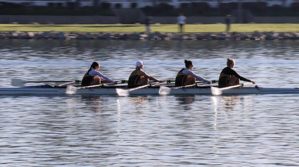 A group of people rowing on a lake

Description automatically generated