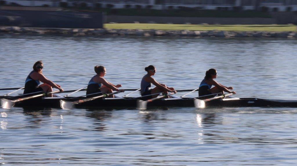 A group of people rowing on a lake

Description automatically generated