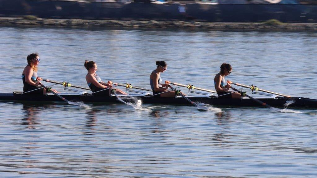 A group of people rowing on the water

Description automatically generated