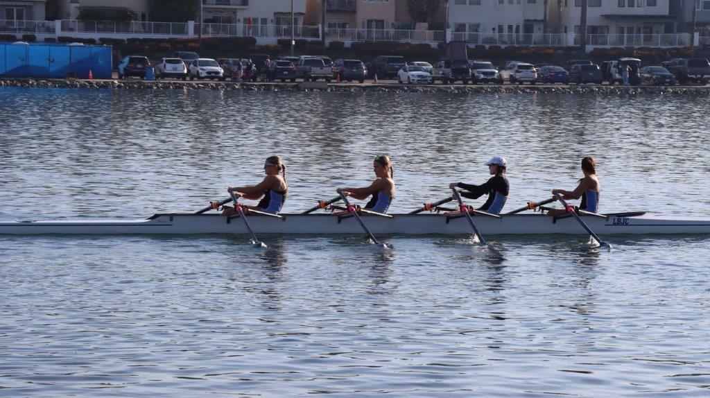 A group of people rowing on a lake

Description automatically generated