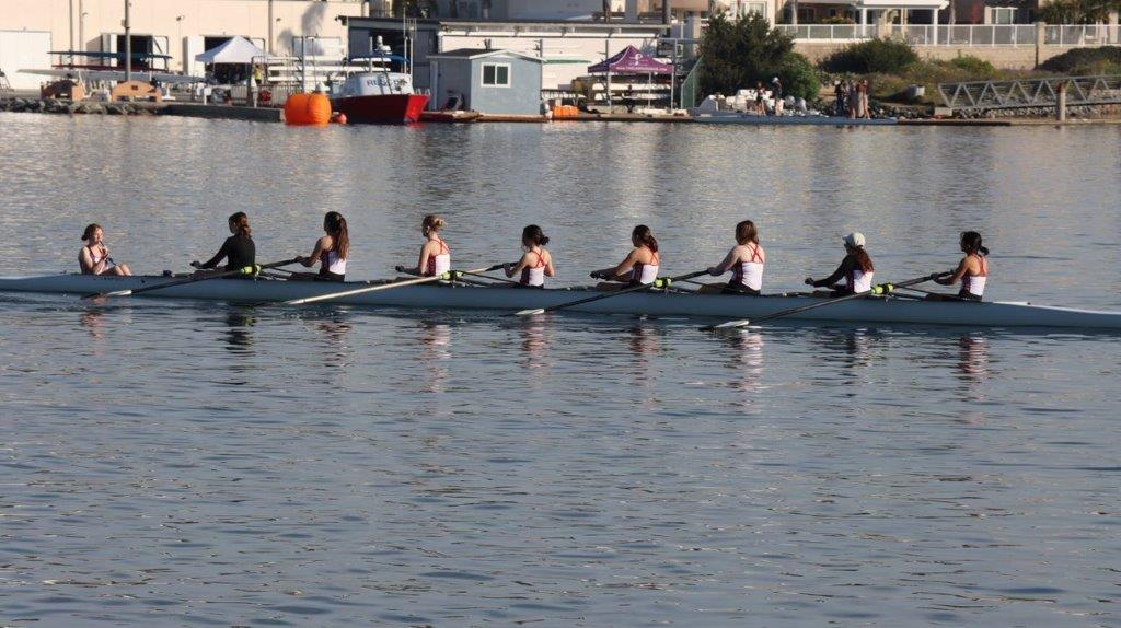 A group of people rowing a boat

Description automatically generated