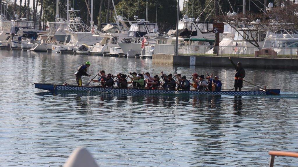 Long shot of a boat with people rowing

Description automatically generated