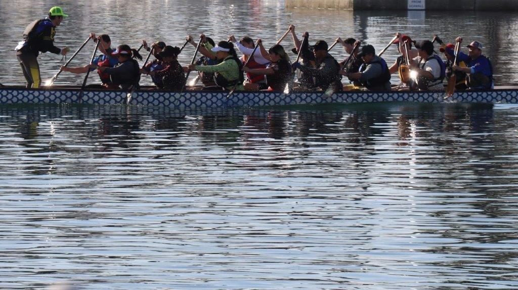 A group of people rowing a boat

Description automatically generated