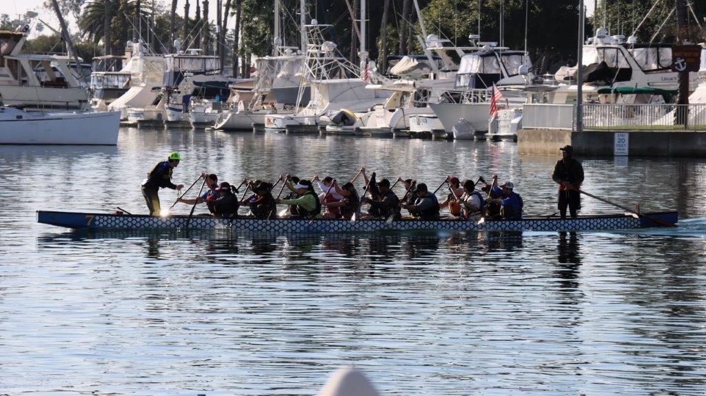 A group of people rowing a boat

Description automatically generated
