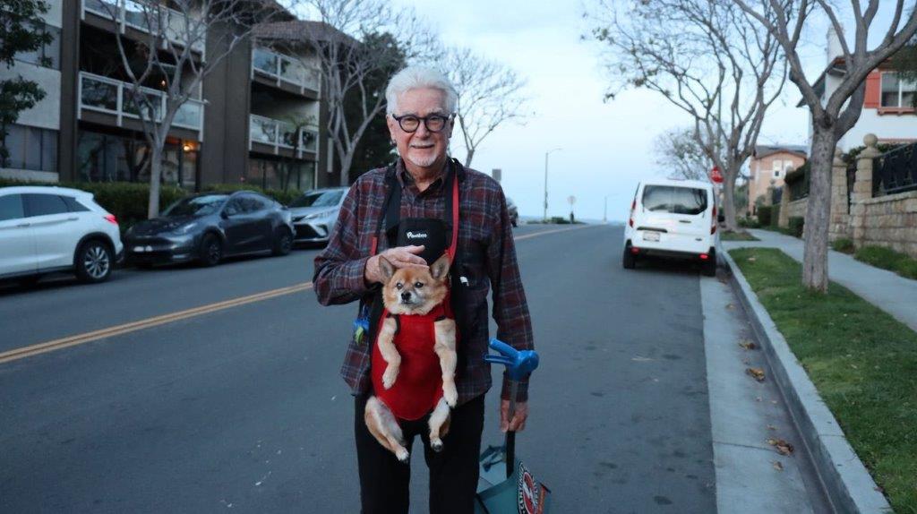 A person carrying a dog on his back

Description automatically generated