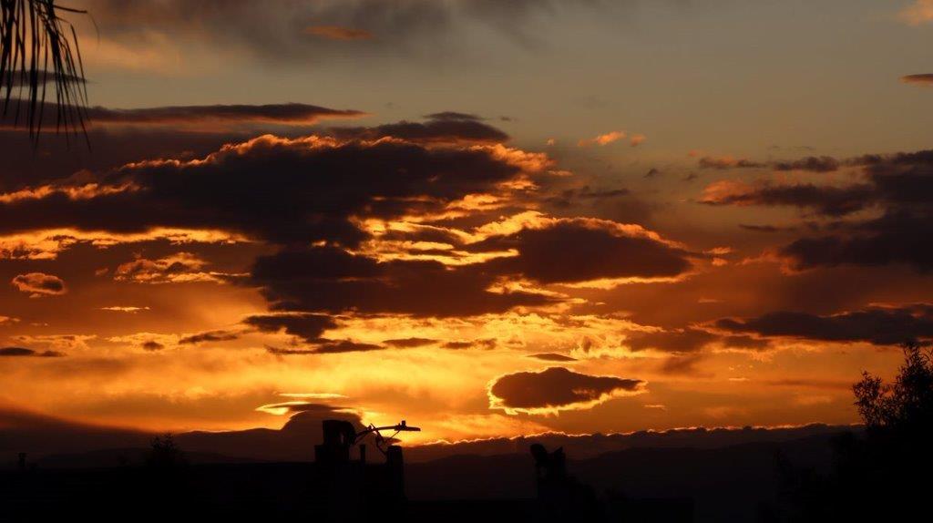 A sunset with clouds in the sky

Description automatically generated