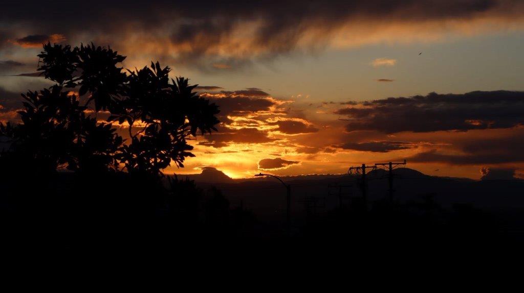 A sunset with clouds and trees

Description automatically generated