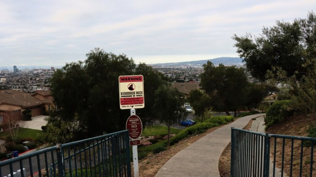A sign on a fence next to a sidewalk

AI-generated content may be incorrect.
