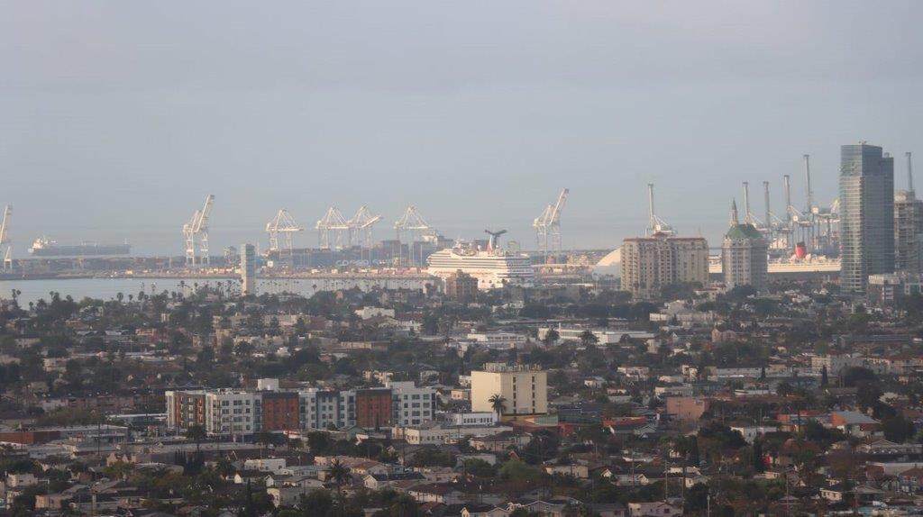 A city with cranes in the background

Description automatically generated