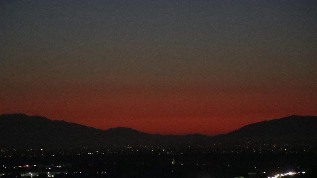 A sunset over a city

Description automatically generated