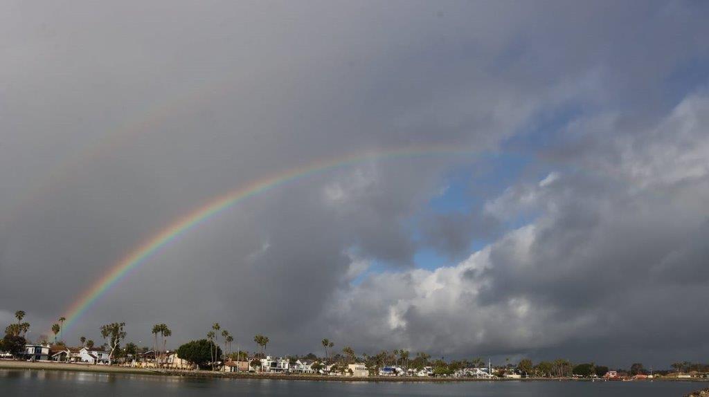 A rainbow over a body of water

Description automatically generated