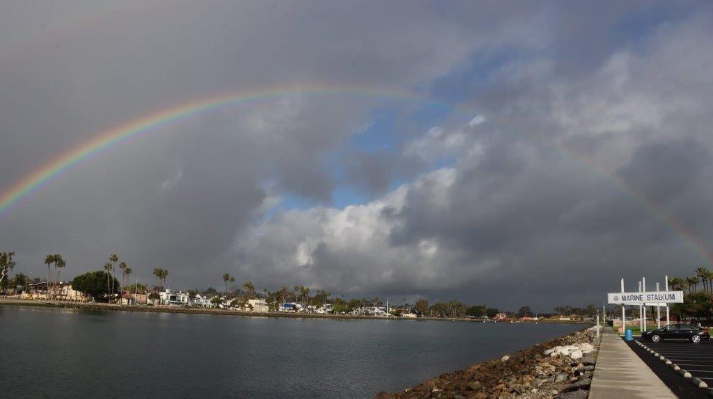A rainbow over a body of water

Description automatically generated