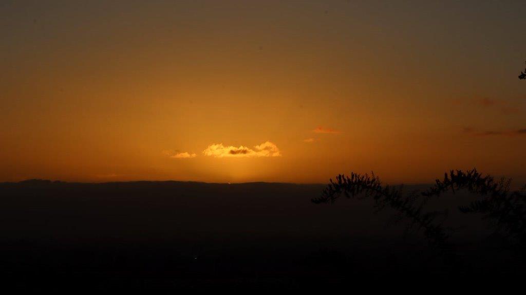 A sunset over a hill

Description automatically generated