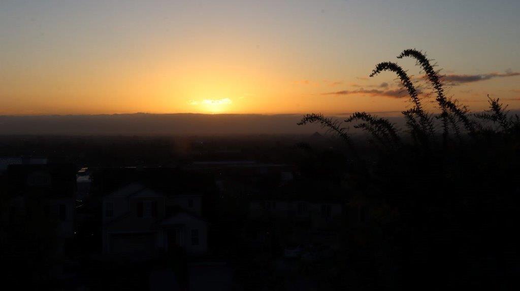A sunset over a city

Description automatically generated