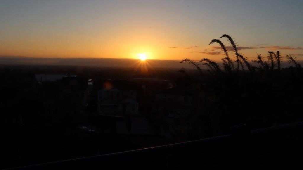 A sunset over a city

Description automatically generated