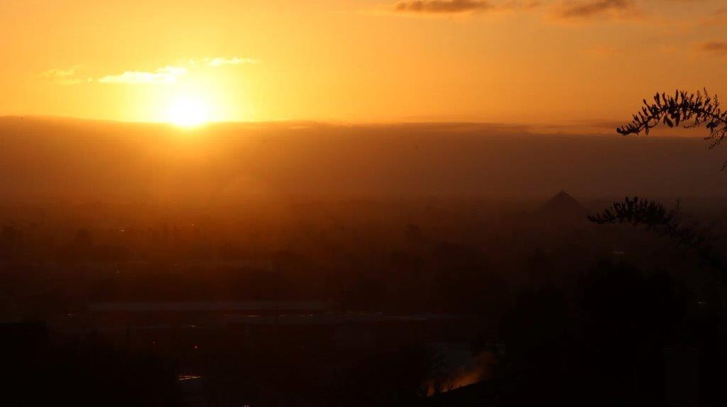 A sunset over a city

Description automatically generated