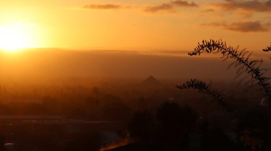 A sunset over a city

Description automatically generated