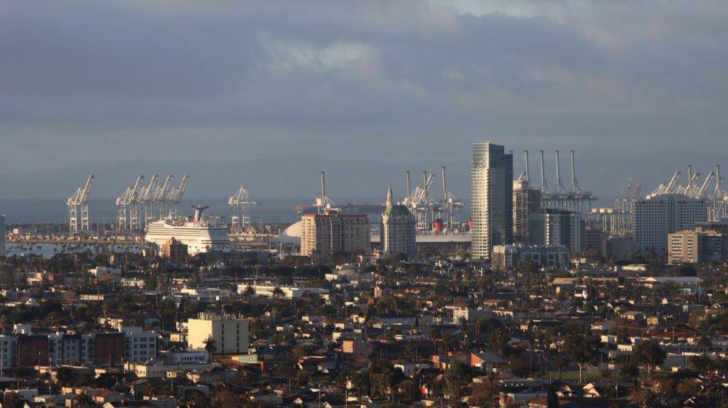 A city with cranes in the background

Description automatically generated