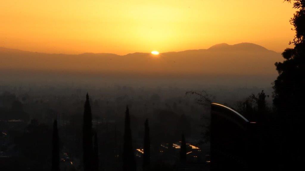A sunset over a city

Description automatically generated