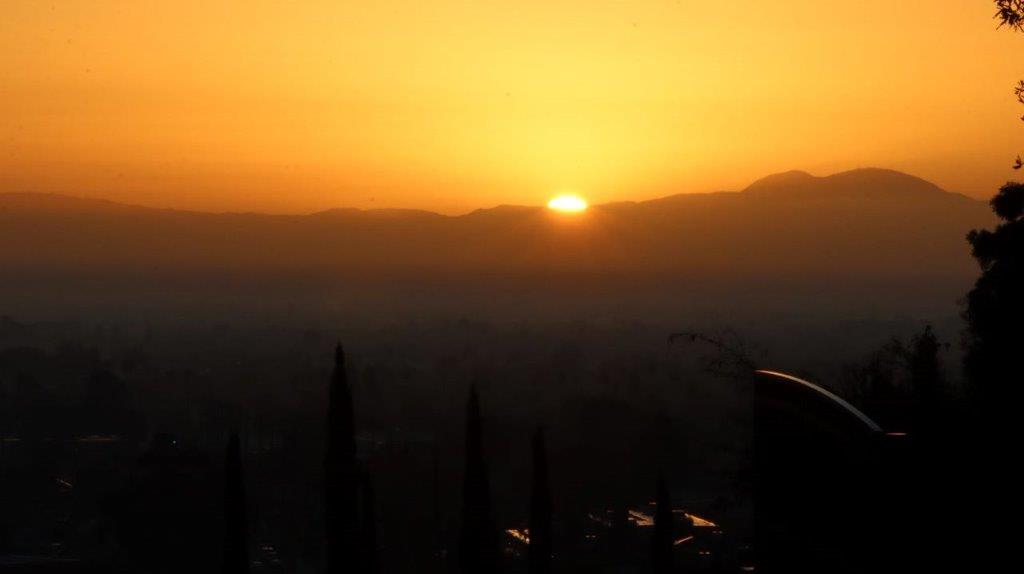 A sunset over a city

Description automatically generated