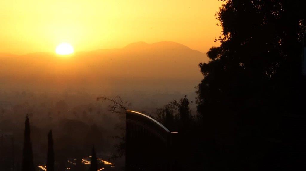 A sunset over a city

Description automatically generated