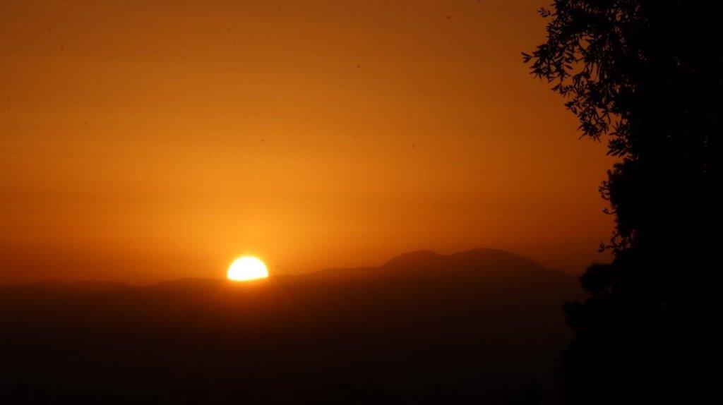 A sunset over a mountain

Description automatically generated