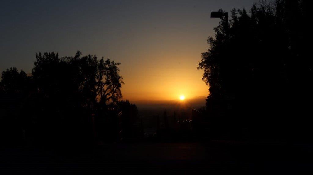 A sunset over a city

Description automatically generated