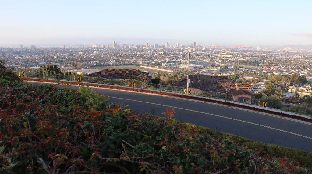 A road with a city in the background

Description automatically generated