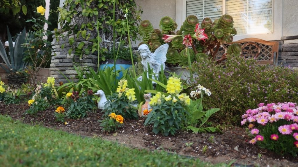 A garden with a statue of a bird and birds

AI-generated content may be incorrect.