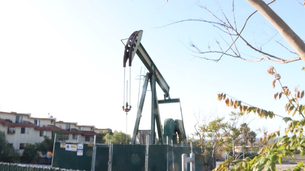 A oil rig in the middle of a field

AI-generated content may be incorrect.