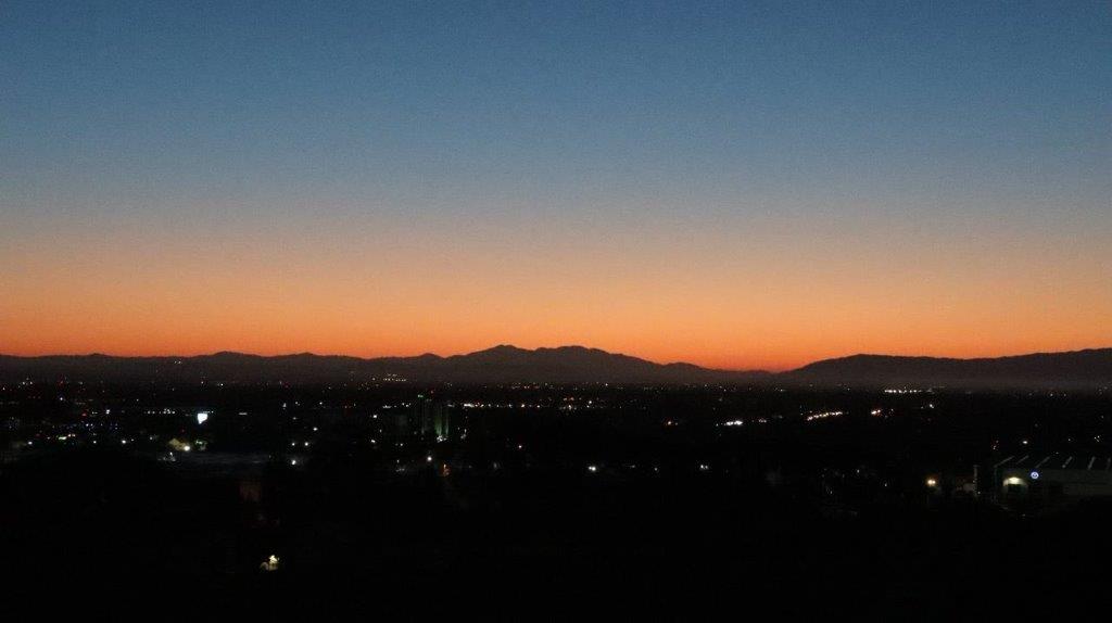 A sunset over a city

Description automatically generated