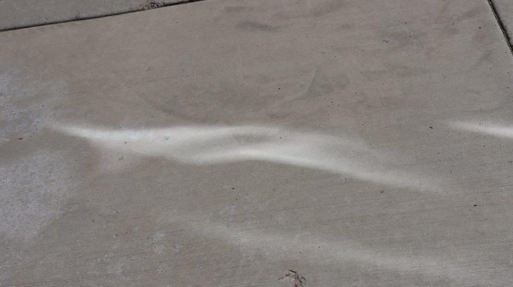A white line on a concrete surface

Description automatically generated