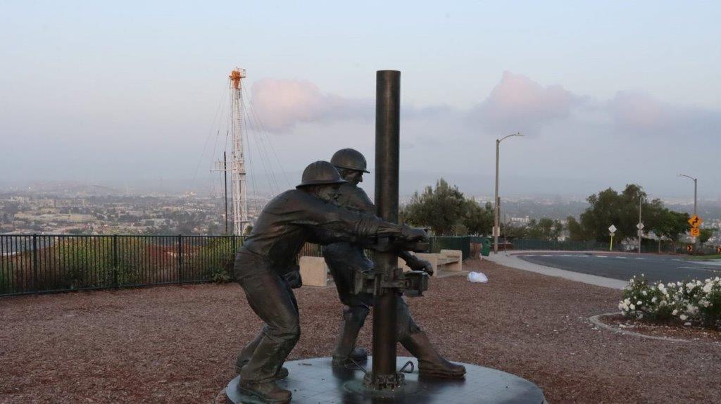 A statue of men holding a pipe

Description automatically generated