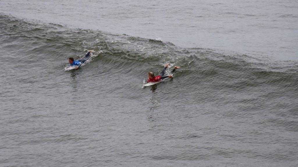 A group of people surfing in the ocean

Description automatically generated