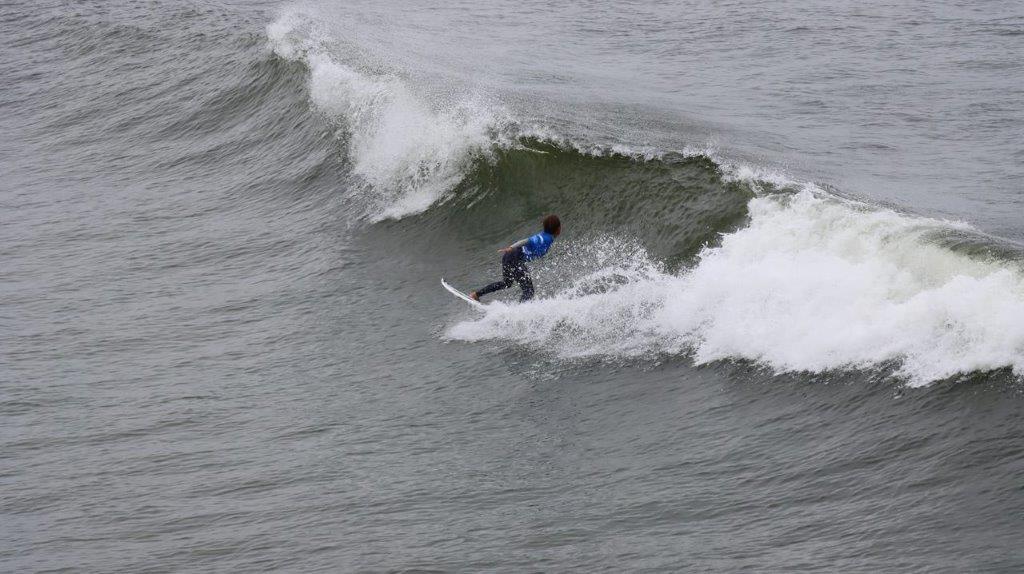 A person surfing in the ocean

Description automatically generated