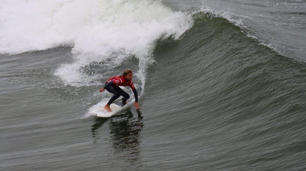 A person on a surfboard riding a wave

Description automatically generated